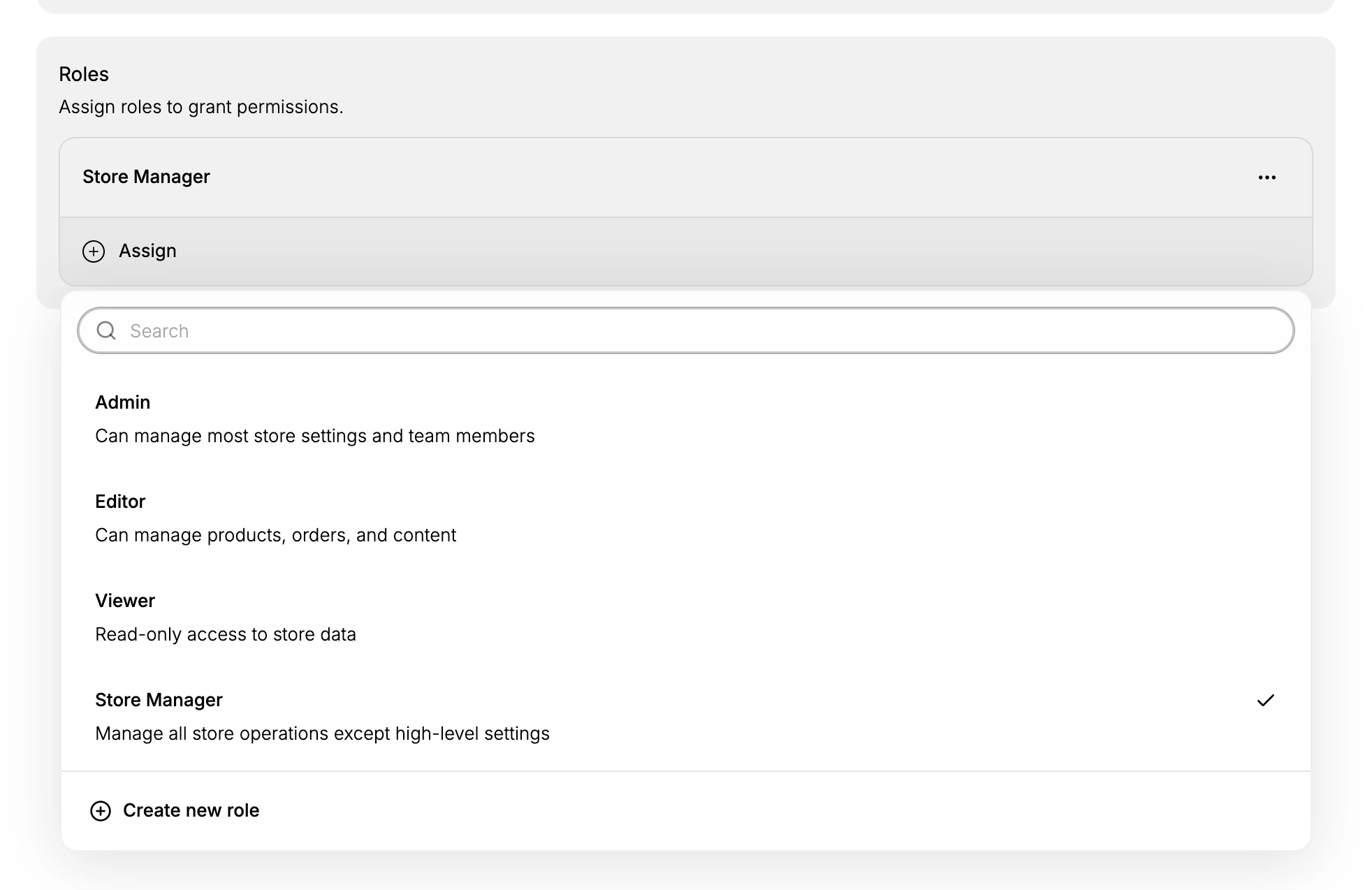 The Assign list open on a member's page, showing Admin, Editor, Viewer and Store Manager with their descriptions, a Search box above them, a tick beside the role already held, and Create new role at the foot