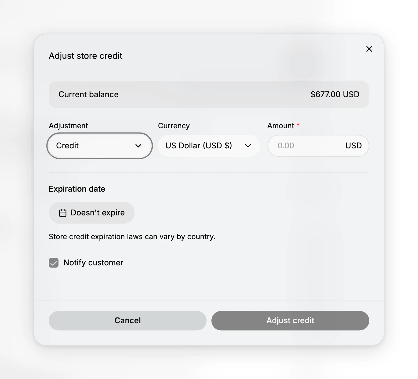 The Adjust store credit dialog. A Current balance row reads $677.00 USD. Below it three controls sit side by side: Adjustment set to Credit, Currency set to US Dollar (USD $), and a required Amount field showing 0.00 with USD beside it. Under a divider, Expiration date offers a control reading Doesn't expire, followed by the line Store credit expiration laws can vary by country, and a ticked Notify customer box. Cancel and Adjust credit sit at the foot