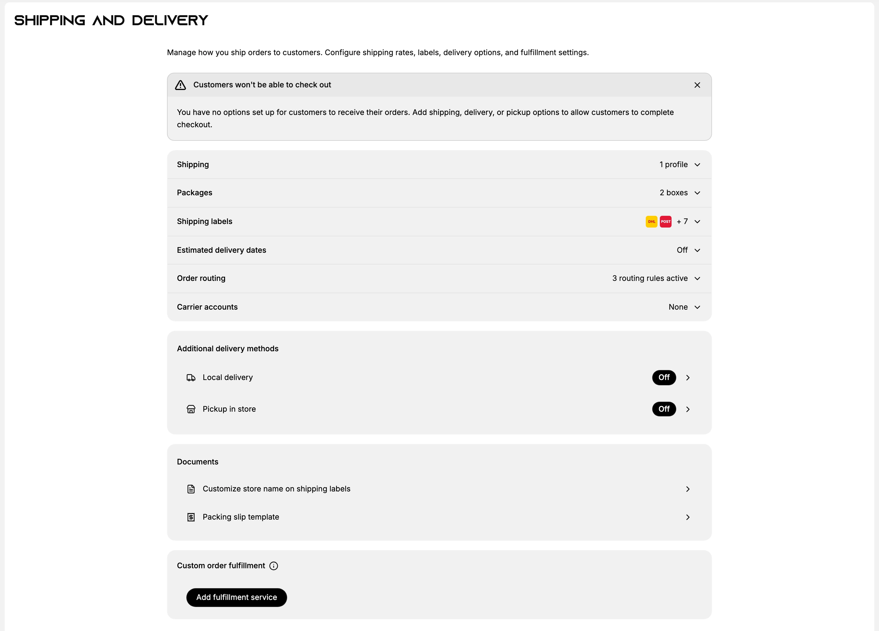 The Shipping and delivery settings page: a description reading Manage how you ship orders to customers, a Customers won't be able to check out warning that can be dismissed, then rows for Shipping with 1 profile, Packages with 2 boxes, Shipping labels showing carrier logos, Estimated delivery dates Off, Order routing with 3 routing rules active and Carrier accounts None, then Additional delivery methods with Local delivery and Pickup in store both Off, a Documents card holding Customize store name on shipping labels and Packing slip template, and a Custom order fulfillment card with an Add fulfillment service button